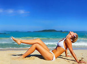 Patient relaxing on beach after breast reduction surgery for comfort and balance in the Wichita metro area