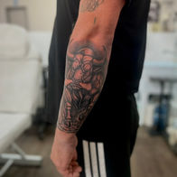 Black and grey illustrative forearm tattoo by Leo