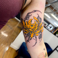 Colour floral and ornamental upper arm tattoo by Osheen