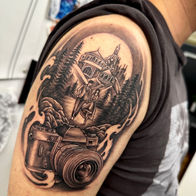 Black and grey illustrative upper arm tattoo by Osheen