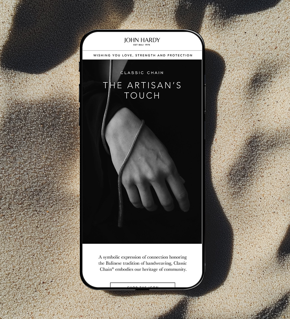 Phone resting on beach sand with a black and white picture of an artisan hand wrapped around by a silver necklace