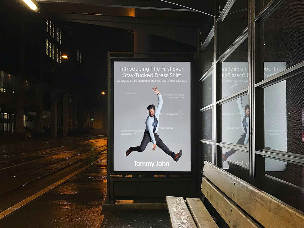 Illuminated bus shelter display at night with an AD of a man jumping in a button-down shirt, pant suit and dress shoes
