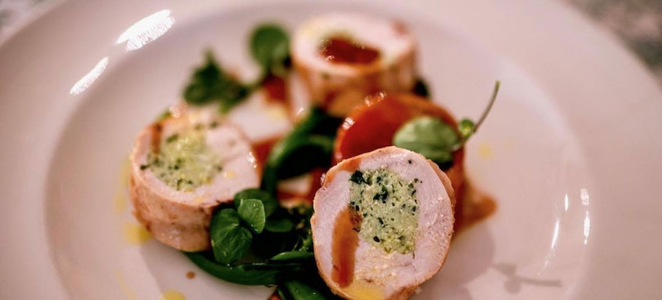 Plated chicken roulade with herbs and sauce