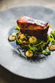 Crispy pork belly with greens and sauce