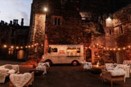 Night event at a castle with food truck and string lights