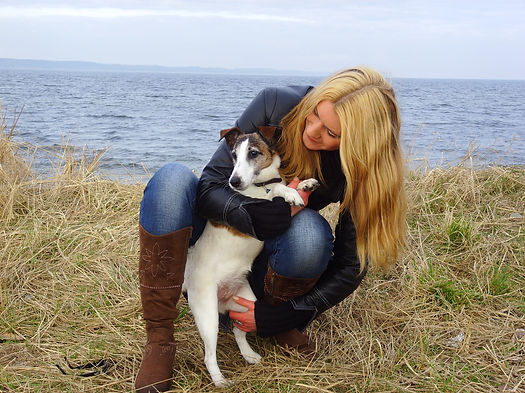 Nicole umarmt ihren Hund am Meer