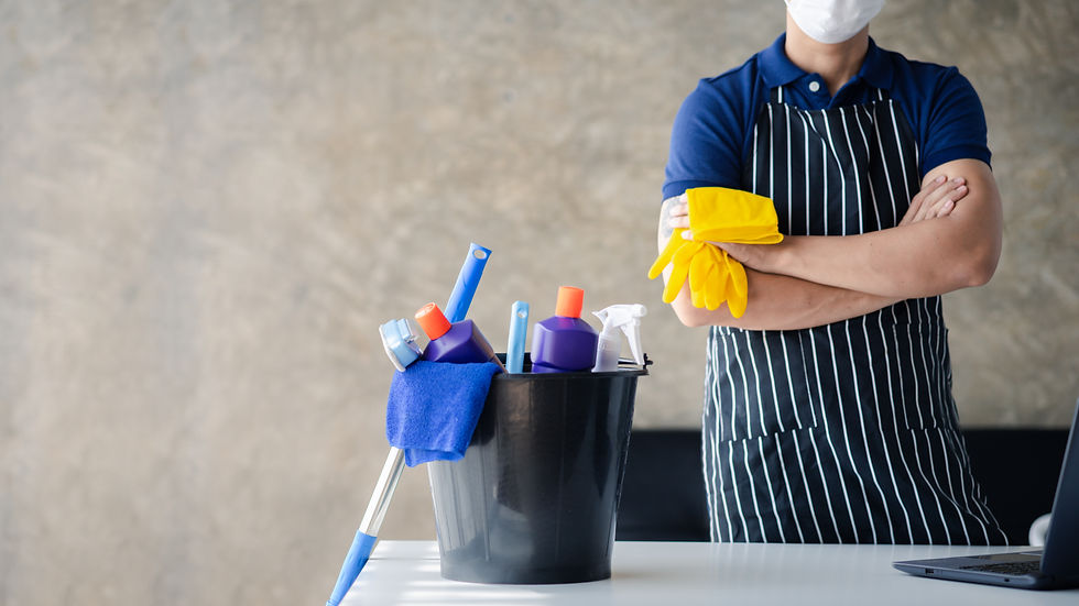 A person positioned by the tables, equipped with cleaning tools.