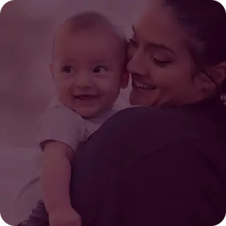 Maman souriante tenant son bébé dans les bras, moment de complicité parent-enfant à Paris