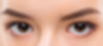 Close-up of a person's eyes with brown irises and neatly shaped eyebrows, showing a calm expression. Bright, even lighting.