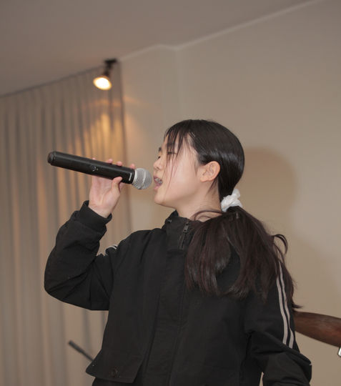 Girl student singing with a microphone.