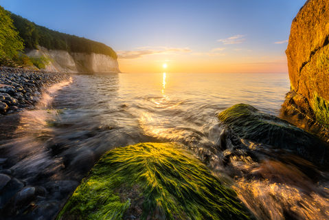 Die spektakuläre Küstenlandschaft von Rügen. Bei Sonnenaufgang branden gerade Wellen an das Ufer.