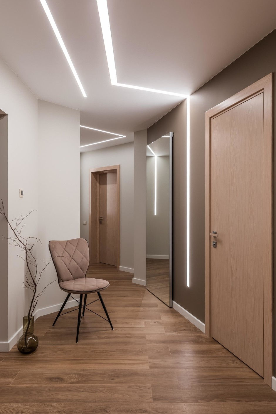 Moderner Flur mit weißer Spanndecke und LED-Lichtlinien über Wand und Decke