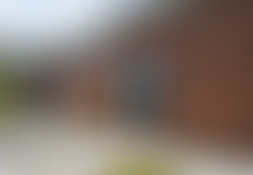 Front view of the red brick Hill School Wilmington building, showcasing the entrance and front office.