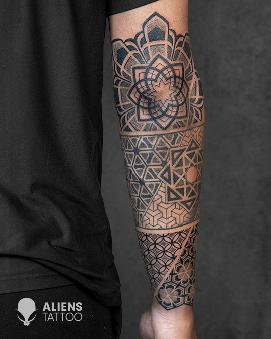Sacred geometry forearm tattoo with layered mandala and tessellation patterns