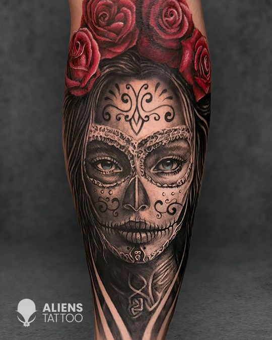 Detailed black and grey sugar skull portrait tattoo with ornamental face patterns and red rose crown on the arm, inked by Aliens Tattoo, the best tattoo studio in pune.