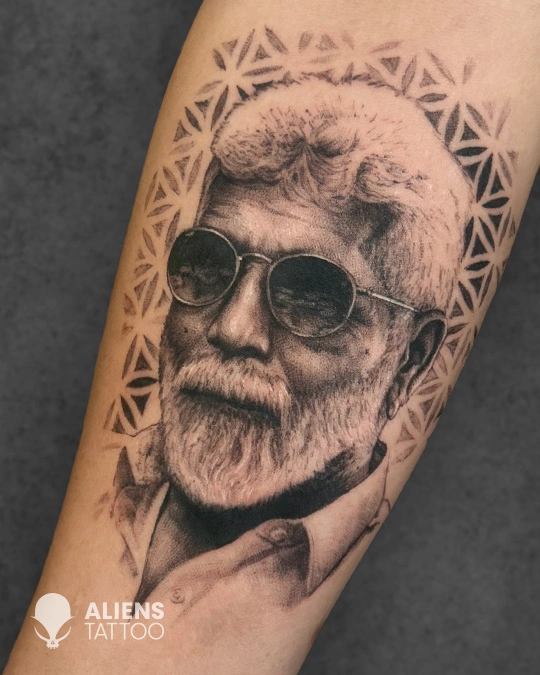 Realistic old man portrait tattoo with glasses and geometric halo design in black and grey style