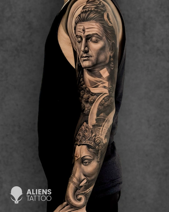 Full sleeve tattoo of Lord Shiva and Lord Ganesha in hyper realistic black and grey tattoo style