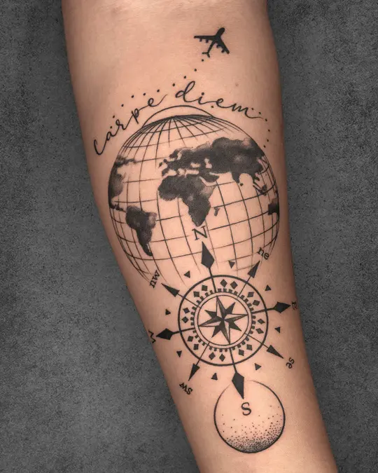 Travel-themed tattoo on a woman’s forearm featuring a globe, compass, and "Carpe Diem," symbolizing global exploration and living in the moment.