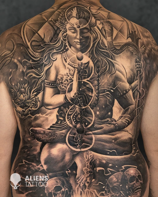 Hyper realistic full back Lord Shiva tattoo with divine expression, trishul, serpent, and cosmic elements in black and grey realism, created by Aliens Tattoo, the best tattoo studio in pune.