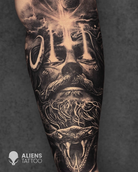 Intense black and grey Aghori Shiva-inspired tattoo featuring ash-smeared face, third eye symbolism, and serpent motif on the forearm, inked by Aliens Tattoo, the best tattoo studio in pune.