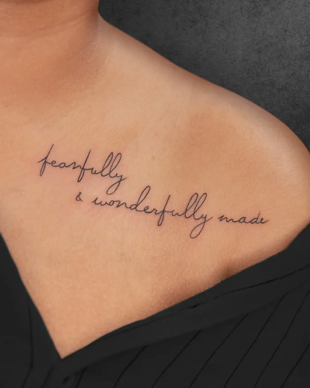 Simple Roman script tattoo on a woman's collarbone celebrating self-acceptance and individuality.