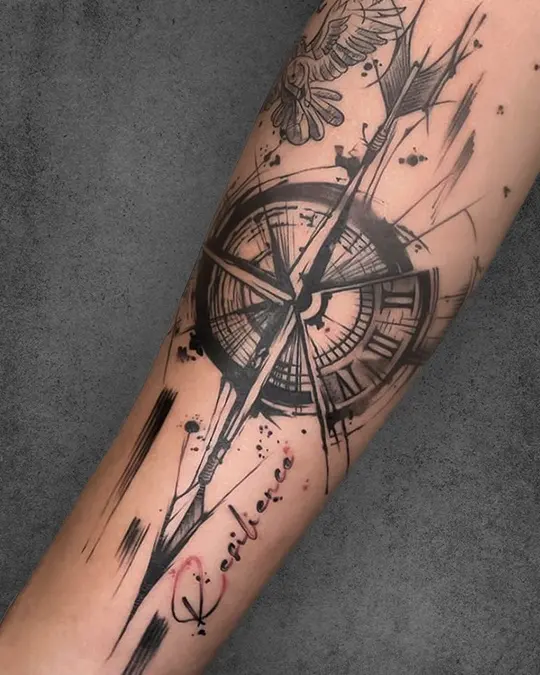 Artistic forearm tattoo of a compass with shattered glass on a man’s arm, paired with "Resilience," reflecting the journey through life's challenges.
