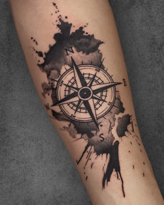 Watercolor-style compass tattoo on a woman’s forearm, symbolizing guidance and direction for travel enthusiasts.