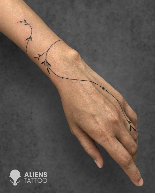 Delicate fine line vine tattoo on hand and wrist at best tattoo studio in Delhi GK1