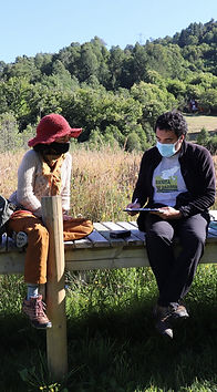 una propietaria de tierras y el presidente de la ong, conversando sentados en una tarima