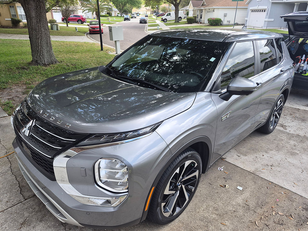 A grey Mitsubishi Outlander PHEV showing mirror-like reflections on the hood after a professional exterior detail at Primal Detailing. The image highlights the results of an Adam’s One-Step polish and triple-layer sacrificial protection in the 32258 Jacksonville area.