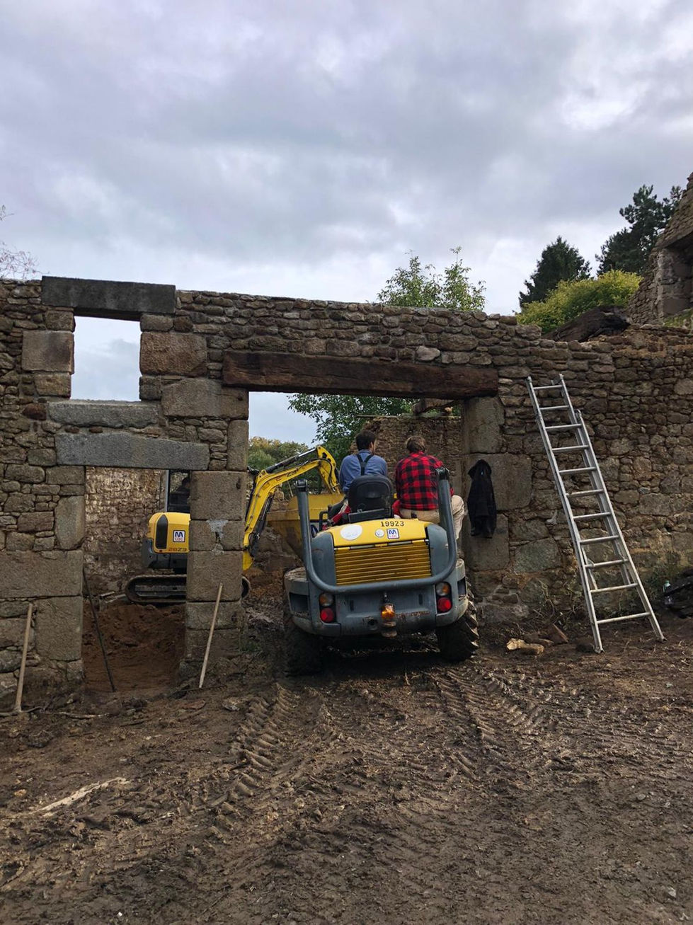 Détail de l'ossature bois restaurée d'une grange transformée en habitation, mettant en avant le travail de maçonnerie effectu