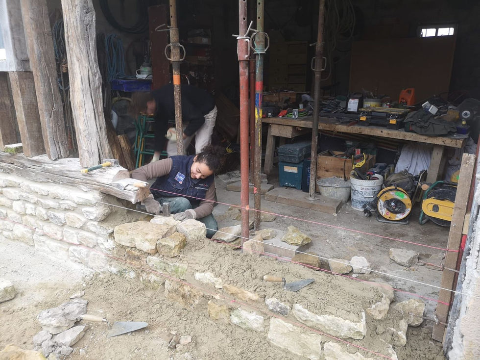 Façade en colombages rénovée avec soubassement en pierre calcaire sur chantier en Basse-Normandie