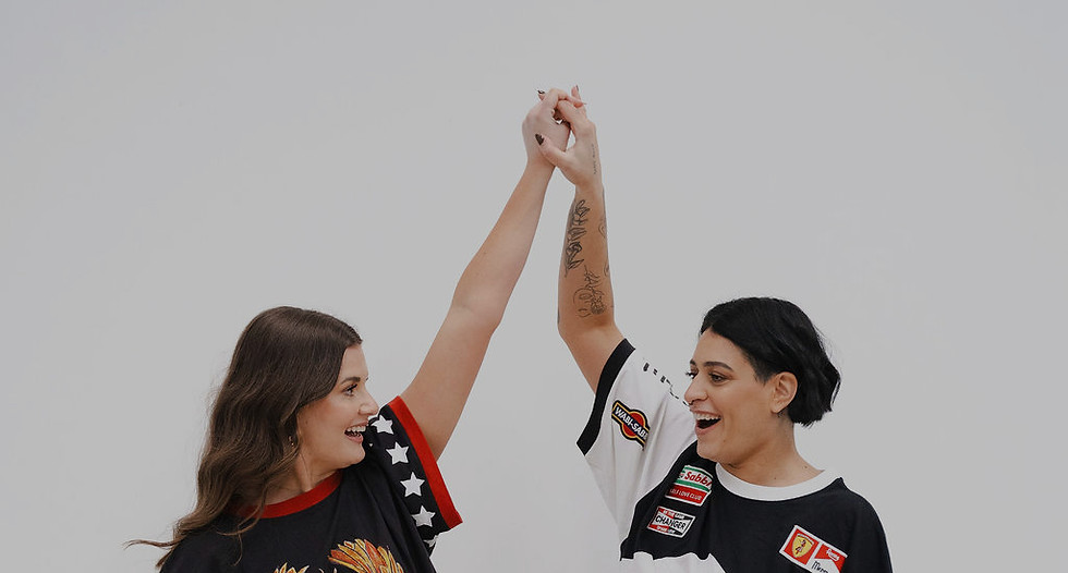 Two artists wearing Disco Rodeo shirts high-fiving, representing creative collaboration and bold self-expression.