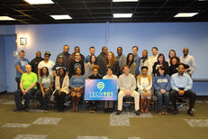 Tech901 admissions process students holding school sign.