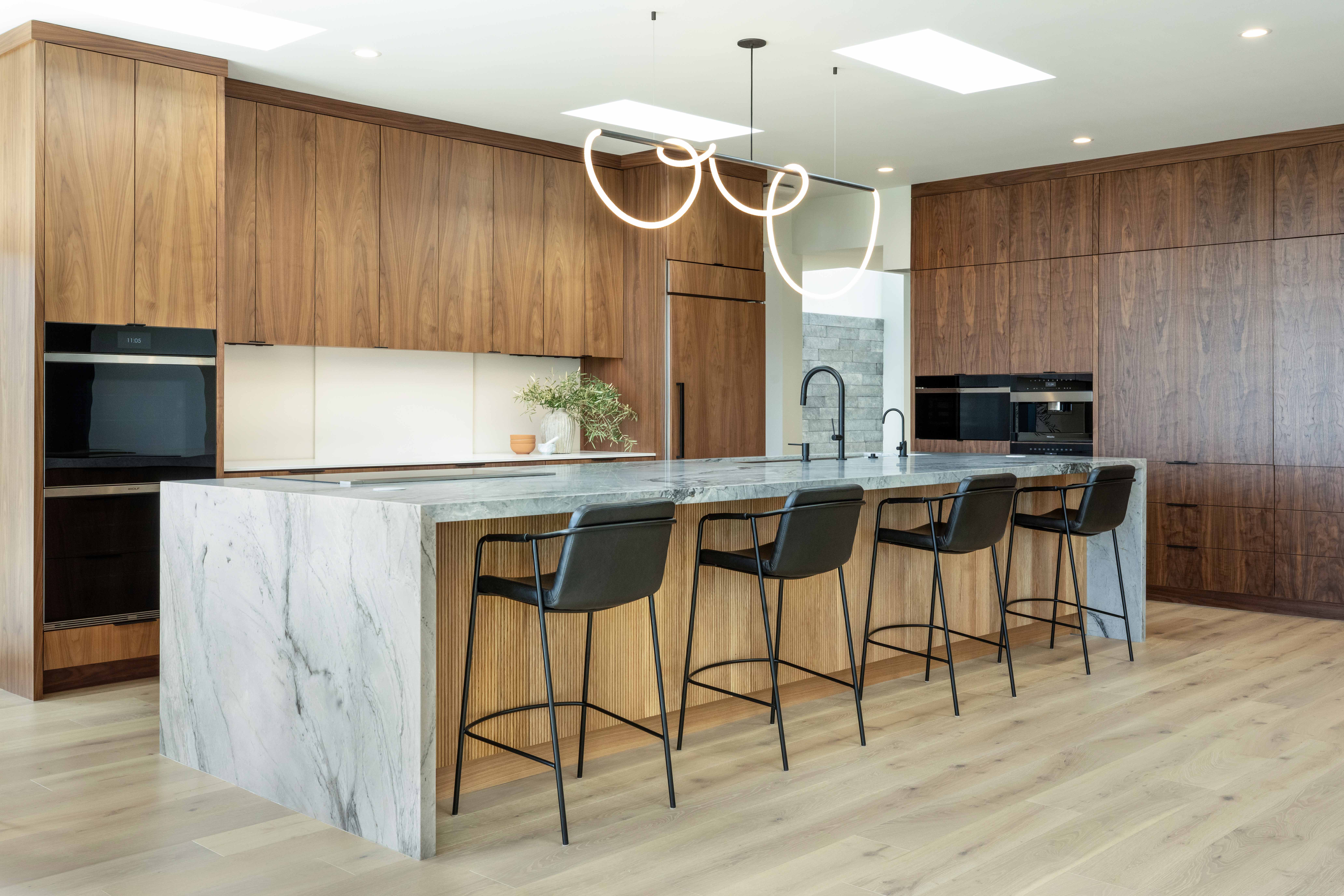 The Rancho kitchen’s stone waterfall island, wood cabinetry and seating