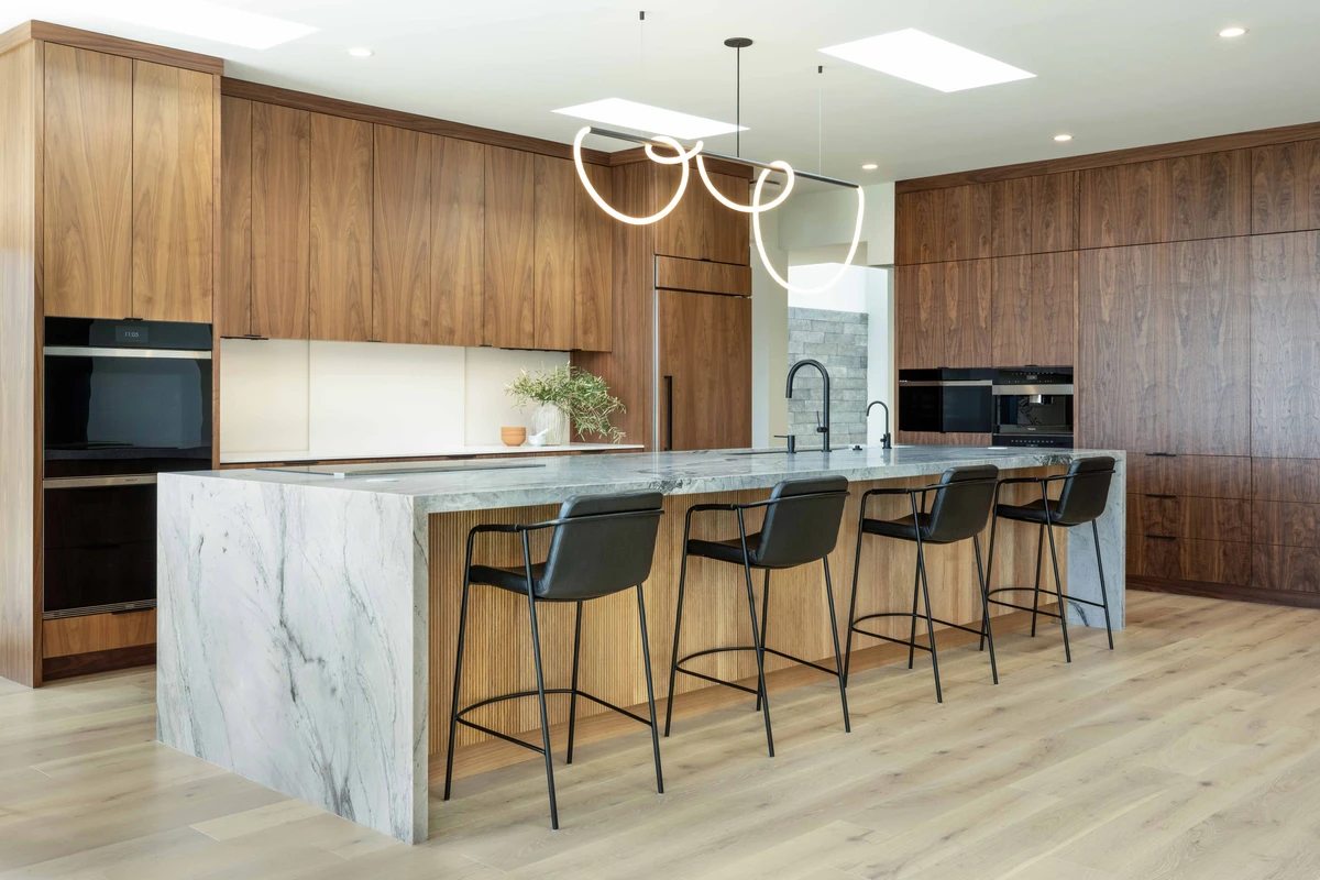 The Rancho kitchen’s stone waterfall island, wood cabinetry and seating