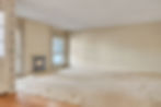 Empty residential living room with fireplace and large windows
