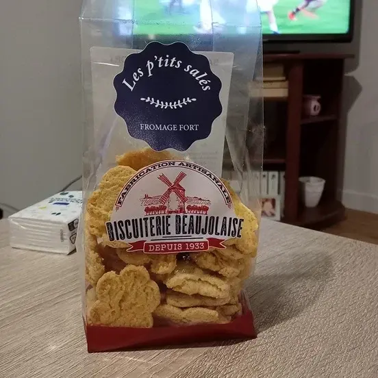 Ceci est un sachet de P'tits salés fromage fort sur une table basse de salon