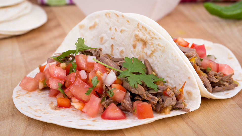 Eye-level view of a colorful plate of skirt steak fajitas with tortillas, guacamole, and pico de gallo