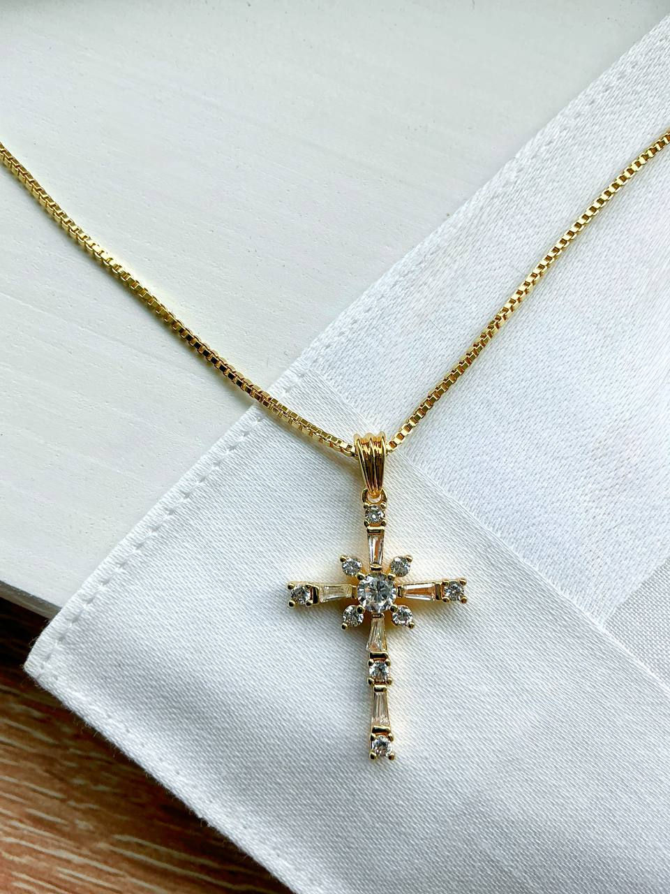 Miniature : Gold cross necklace white & gold on a napkin