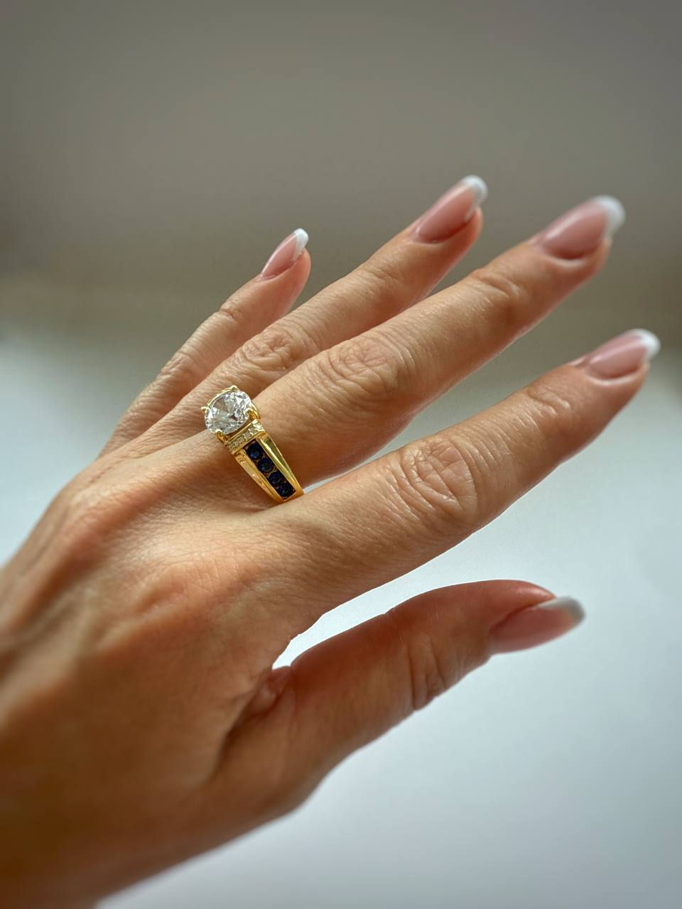 Diamond gold ring 2 carat with sapphires on a finger