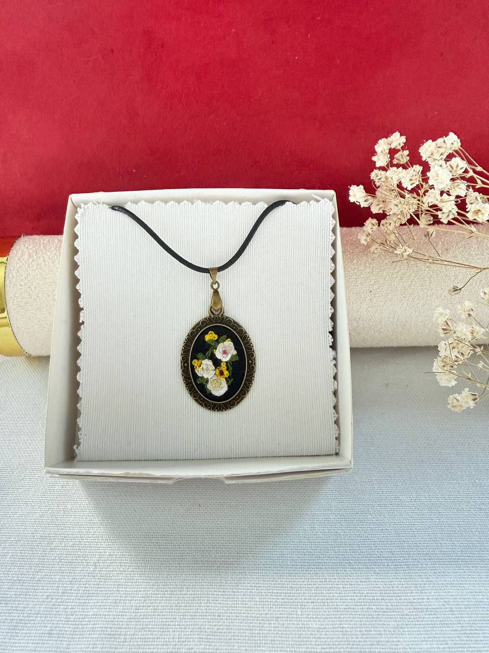 Miniature : Hand embroidered white and yellow floral pendant on black linen in a vintage style oval frame. in agift box