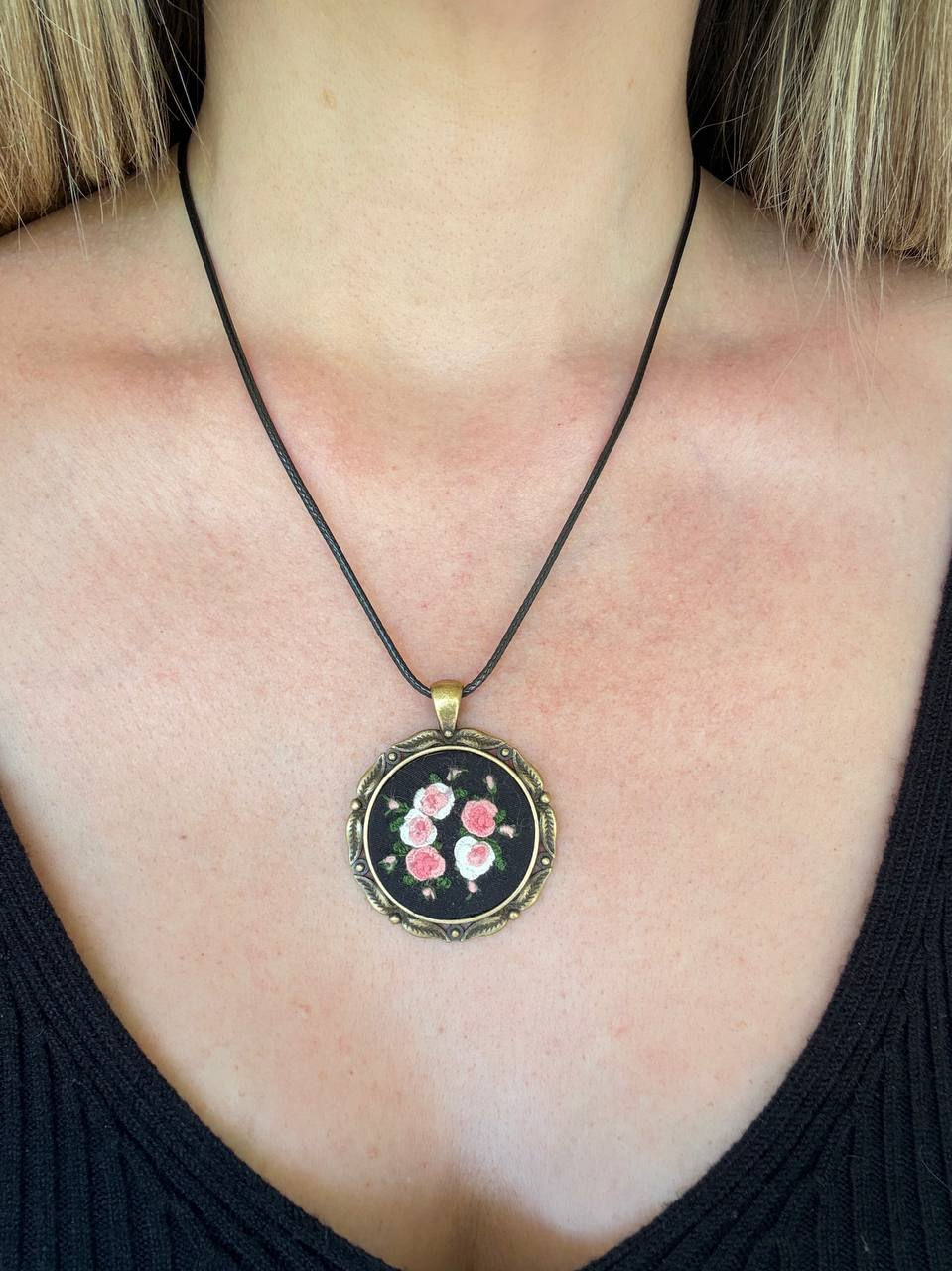 Hand embroidered pink rose pendant in a vintage style round frame with black waxed cord necklace