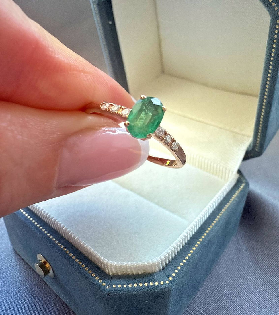Thumbnail: Classic diamond gold ring oval emerald on a finger in front of a box