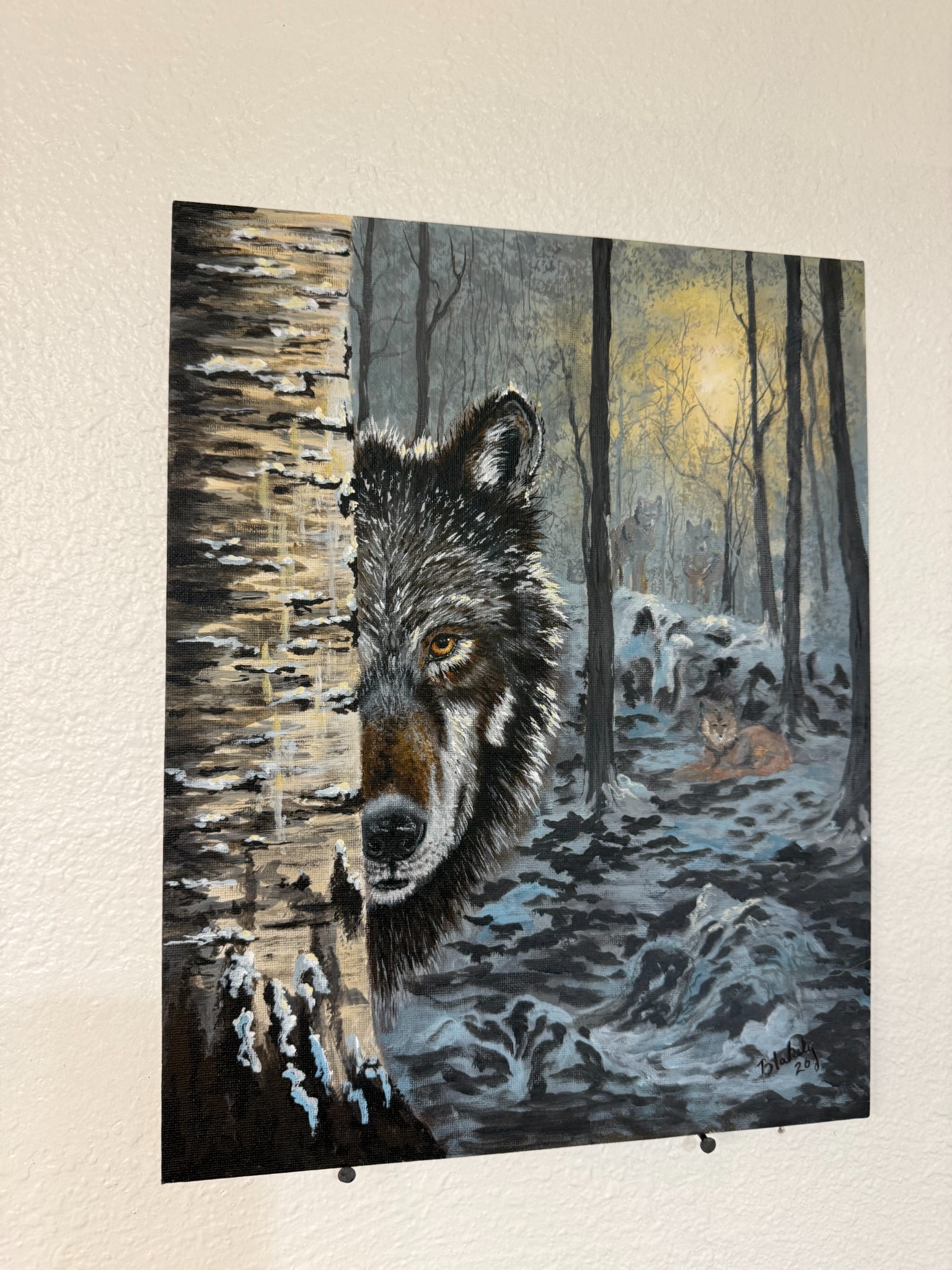 Angled view of Not Quite Alone, showing the unframed wolf painting on an 11 by 14 inch canvas panel.