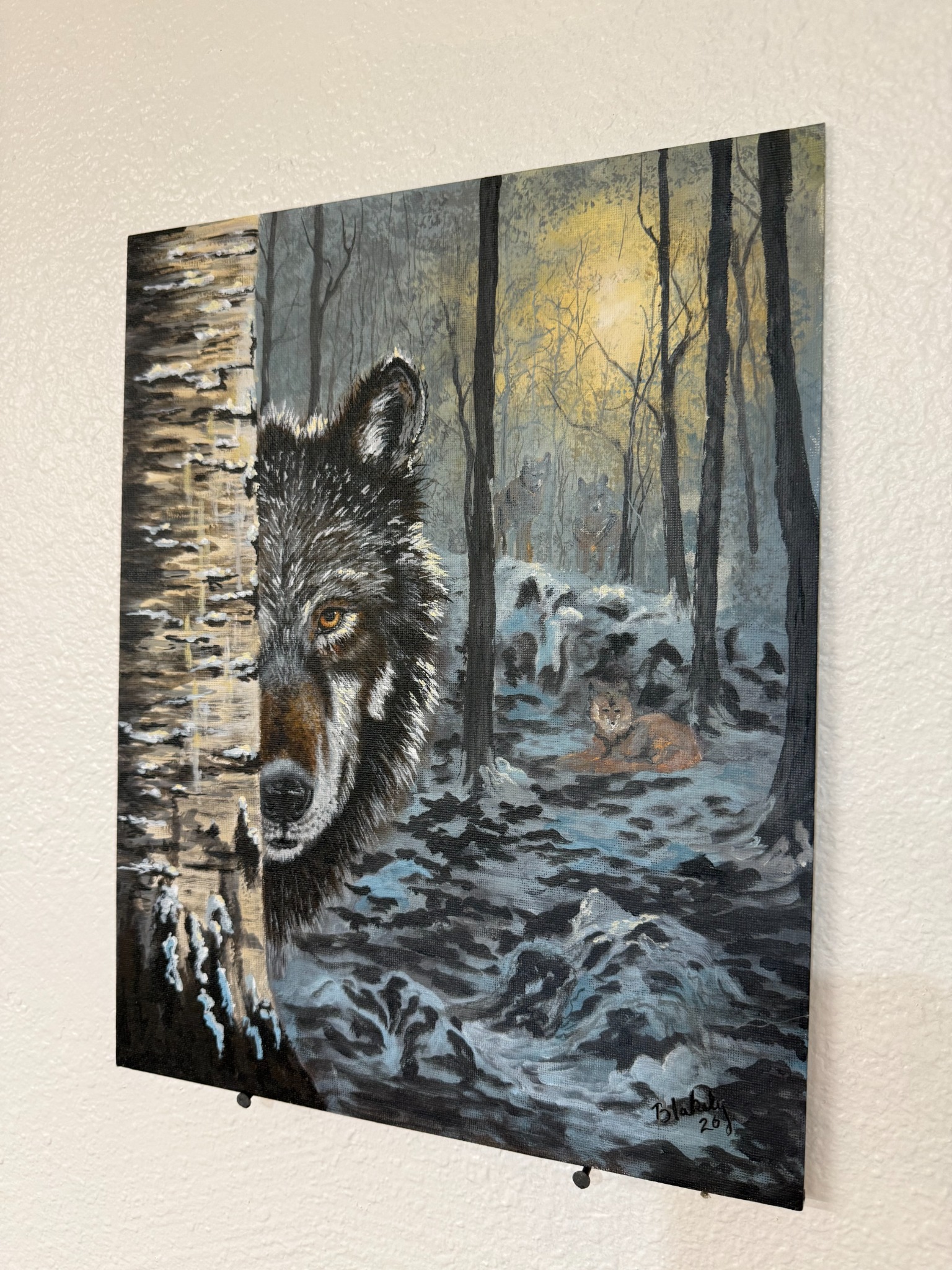 Side view of Hope Blakely’s Not Quite Alone acrylic wolf painting, with golden forest light and wolves among snowy trees.