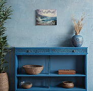 Oil painting of crashing ocean waves on a rocky coastline under a stormy sky, with birds flying in the distance.