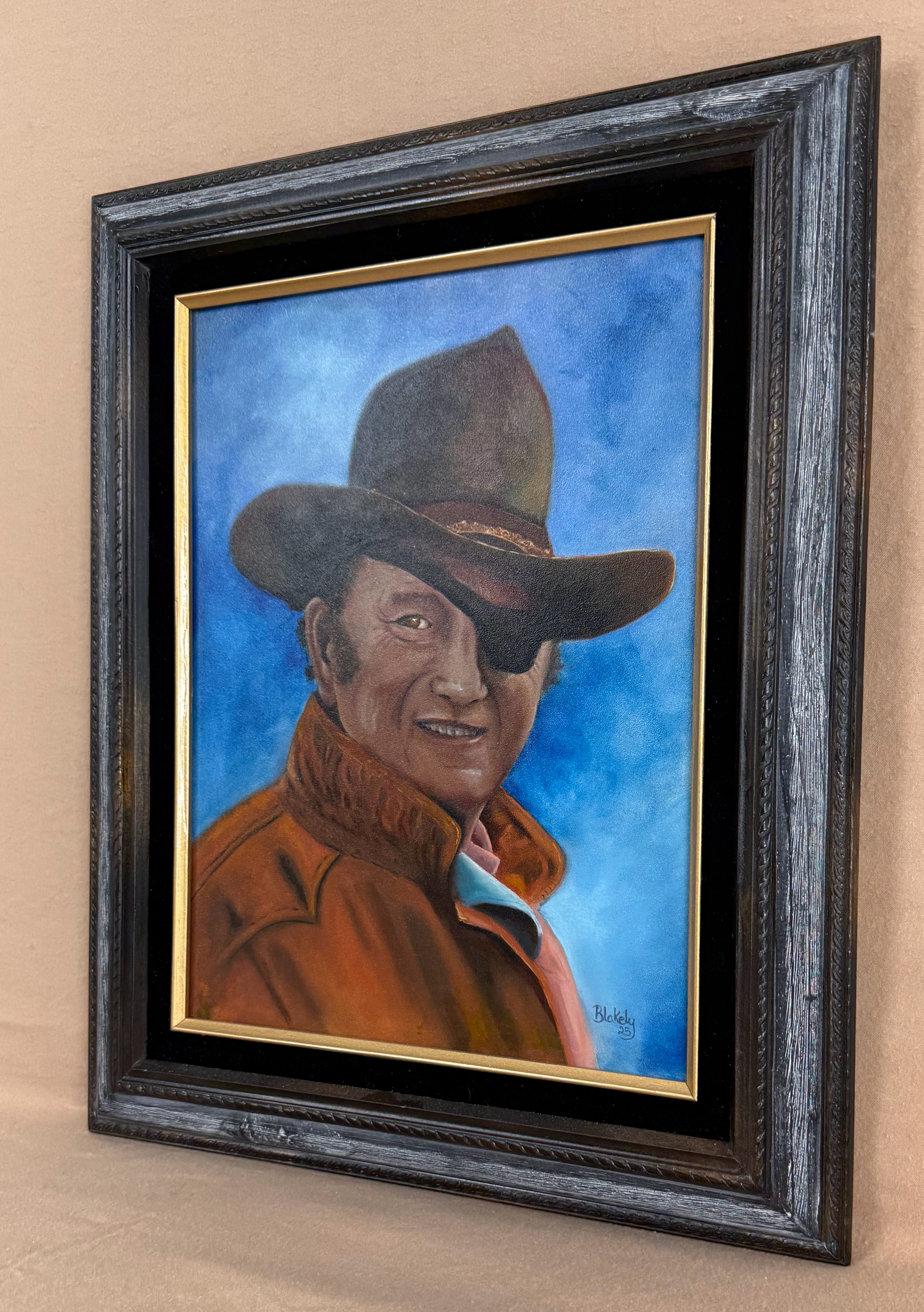 Angled view of The Duke original oil portrait of John Wayne as Rooster Cogburn in its distressed frame