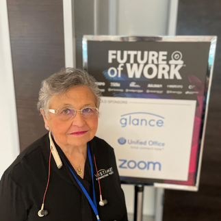 CEO Andrea Robel standing in front of a conference sign