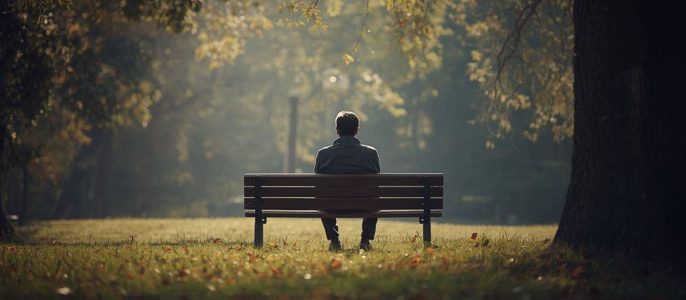 A person sits on a bench under a large tree as sun rays filter through its leaves, creating a serene, golden atmosphere.